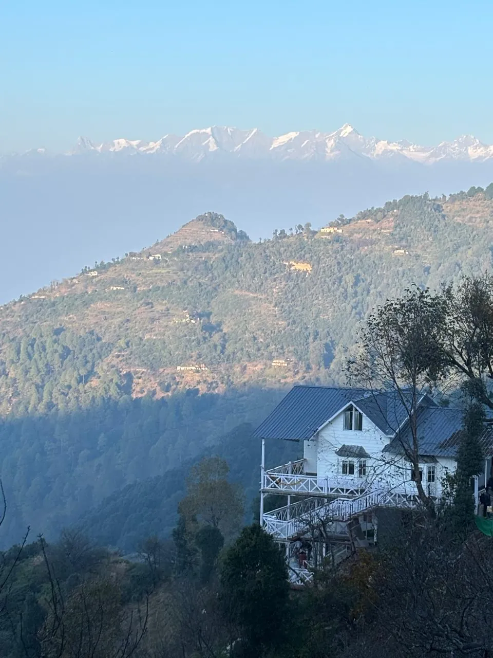 The cottage on its ridge above the Kanatal valley, snow peaks along the horizon